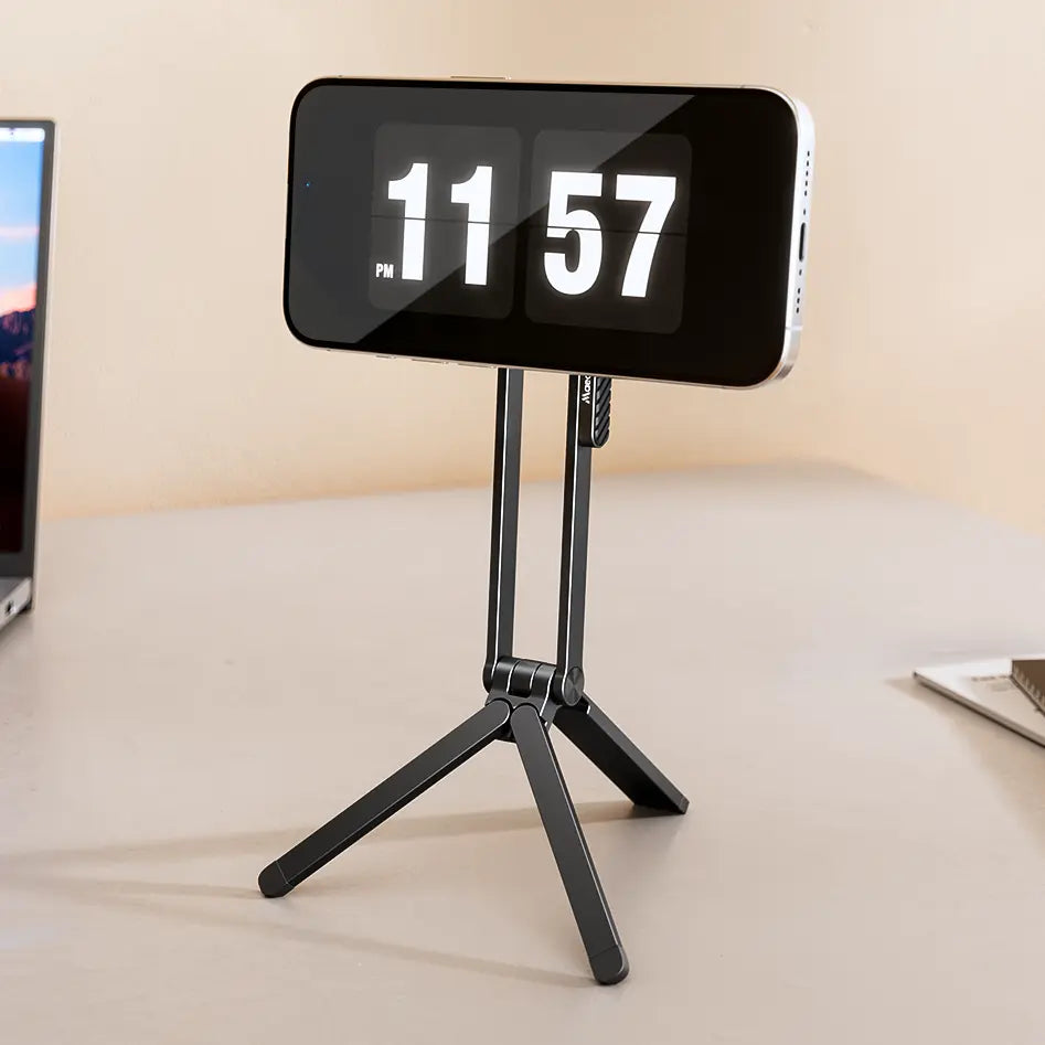 Digital clock on a magnetic tripod stand with a smartphone displaying a desk.